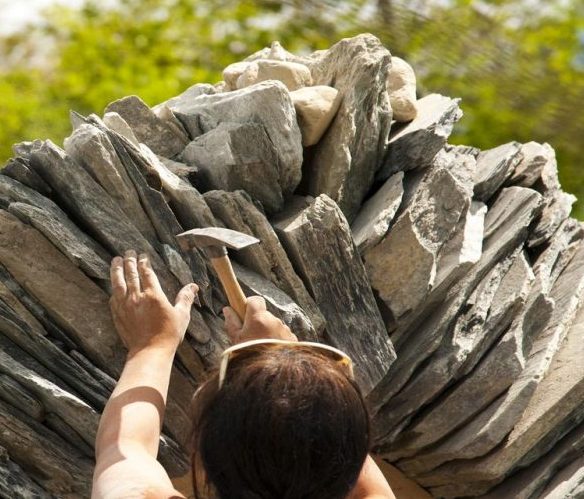 Woman hammers on a piece of wood